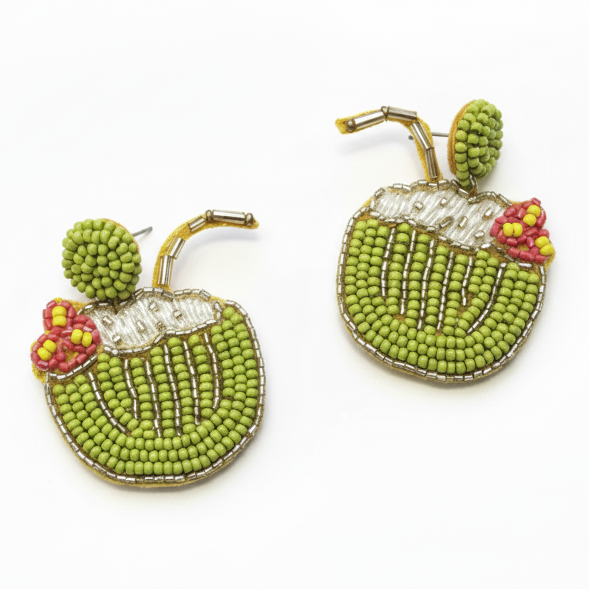 Beaded earrings shaped like coconuts on a wooden surface