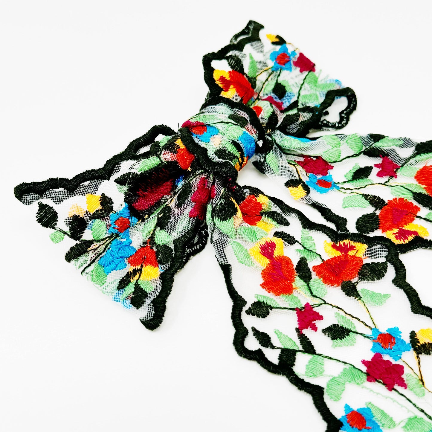 Colorful floral-patterned hair clip with black outline on a white background