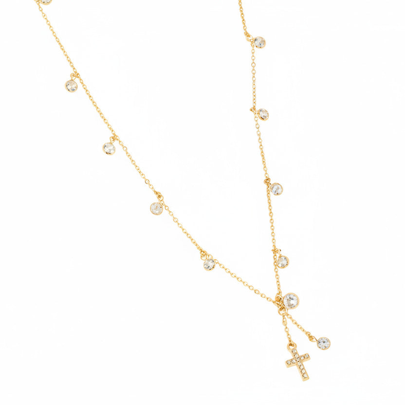Gold necklace with small beads and a cross pendant on a white background