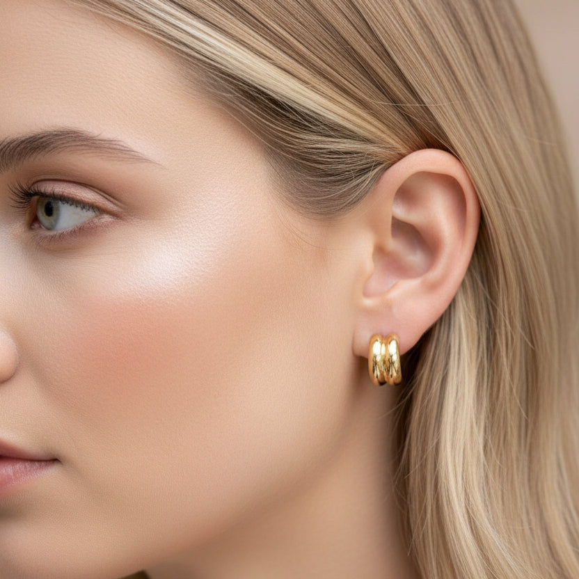 model wearing small chunky gold huggie hoop earring