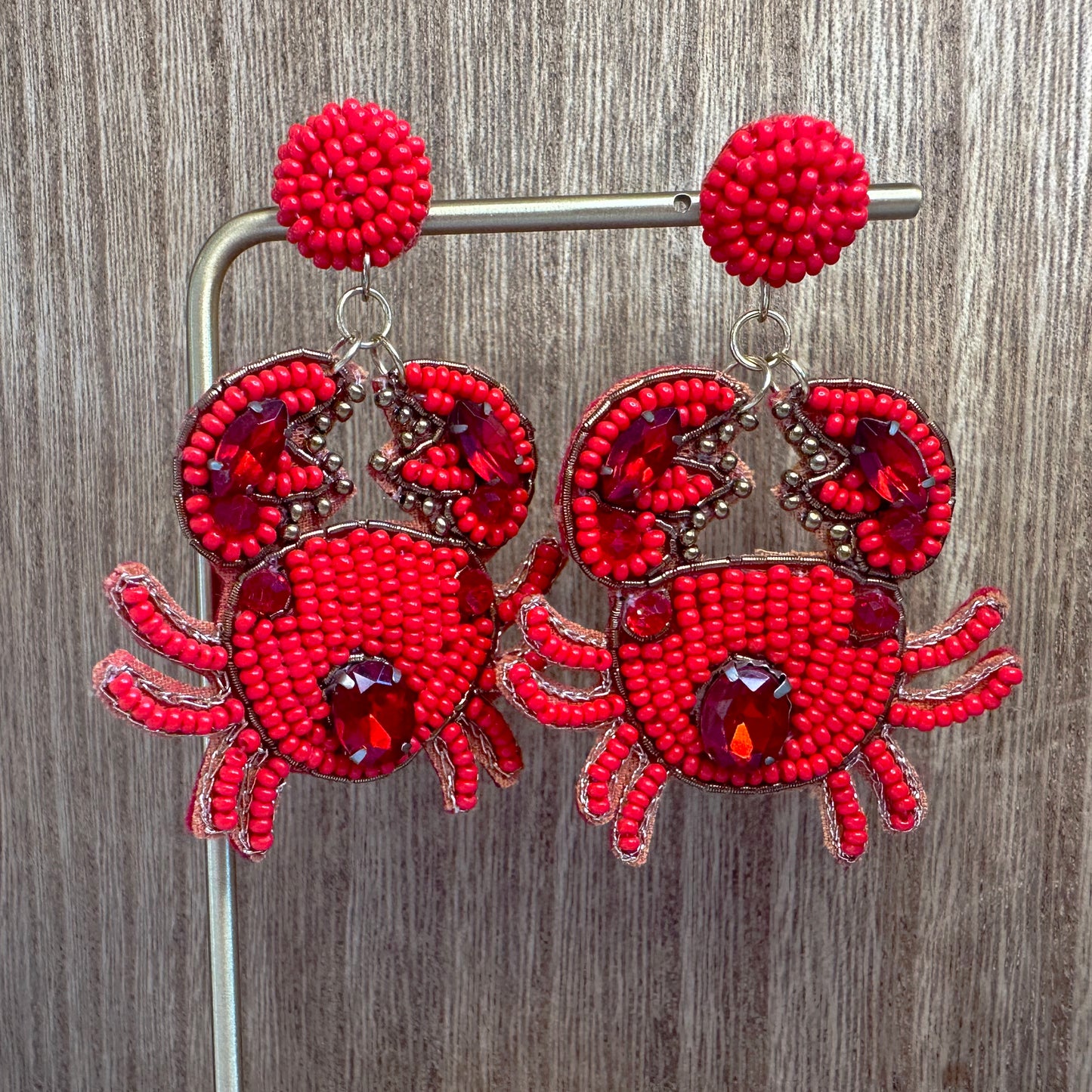 crab beaded earrings against wood background