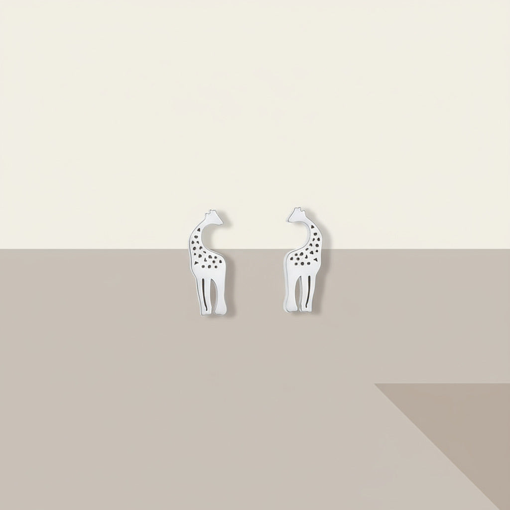 Silver giraffe-shaped earrings on plain background.