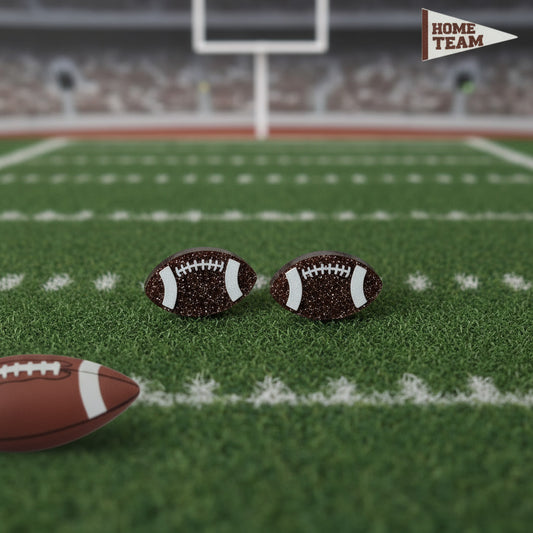 Football earrings on a football field with a blurred stadium background