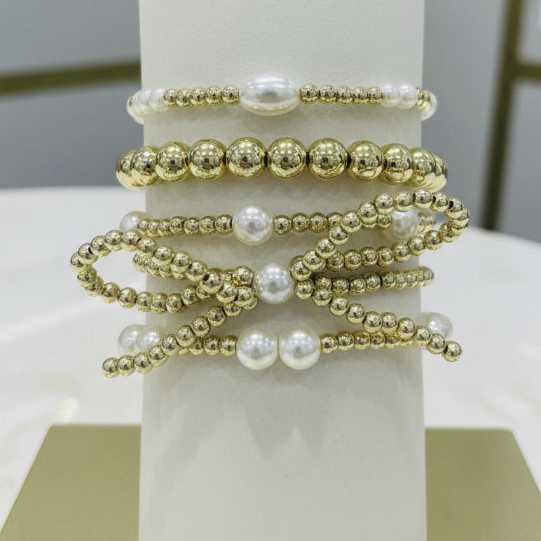 Stack of gold and pearl beaded bracelets 
