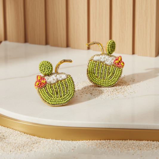 Beaded earrings shaped like coconuts on a marble surface