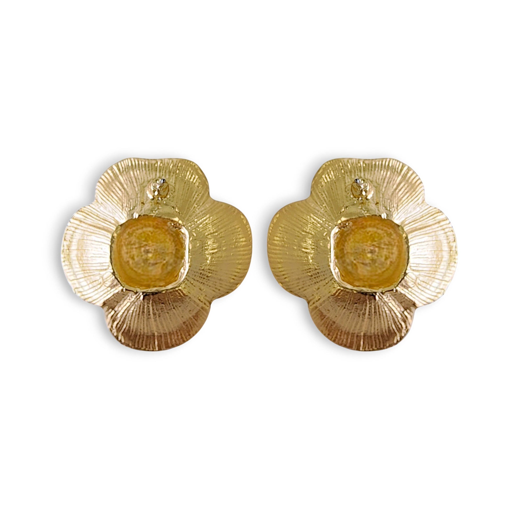Back of gold floral earrings on a white background