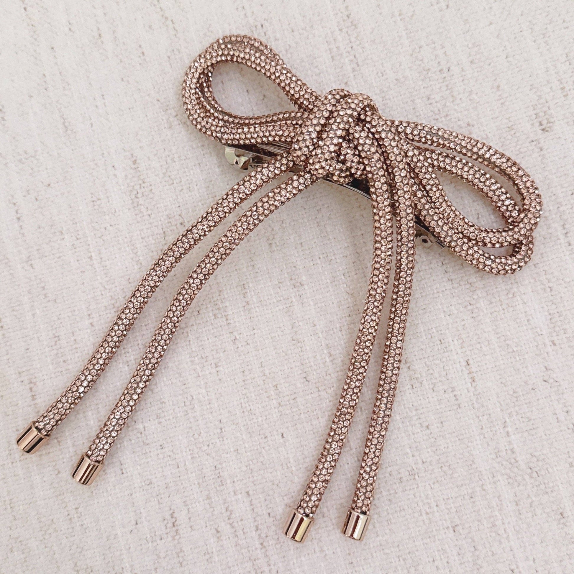 Rose gold sparkly hair clip on beige background