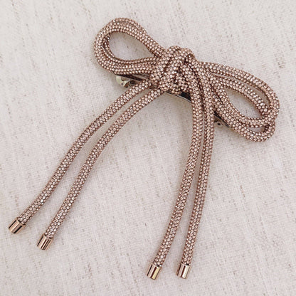 Rose gold sparkly hair clip on beige background