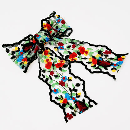 Colorful floral-patterned lace hair clip on a white background