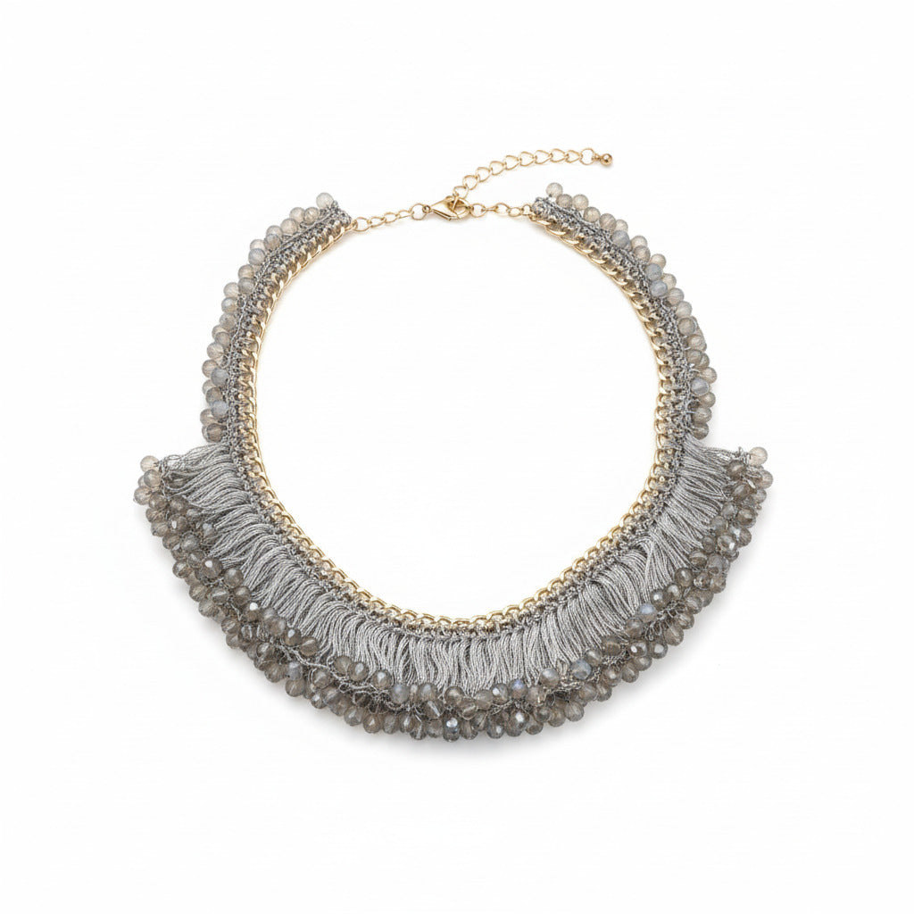 gold necklace with gray fringe and beading against a white background