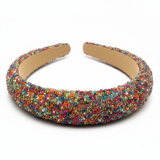 Multi-color beaded headband on a white surface.