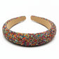 Multi-color beaded headband on a white surface.