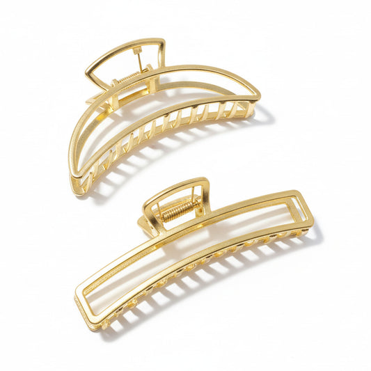 Three gold hair clips on a white background
