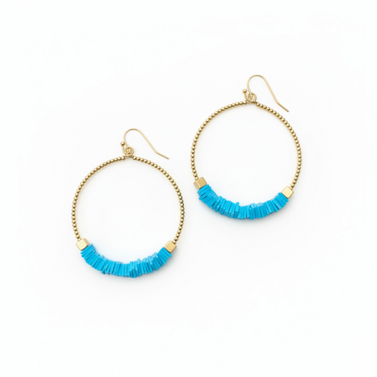 Gold hoop earrings with blue beads on a white background