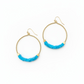 Gold hoop earrings with blue beads on a white background
