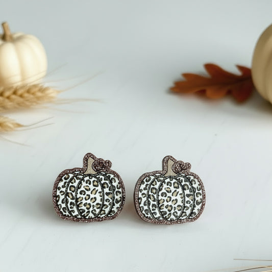 Pumpkin-shaped earrings with leopard print pattern on a light background