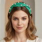 Green headband with pearls on a woman's head.