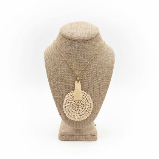 Necklace with a beige pendant on a textured stand with white background