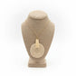 Necklace with a beige pendant on a textured stand with white background