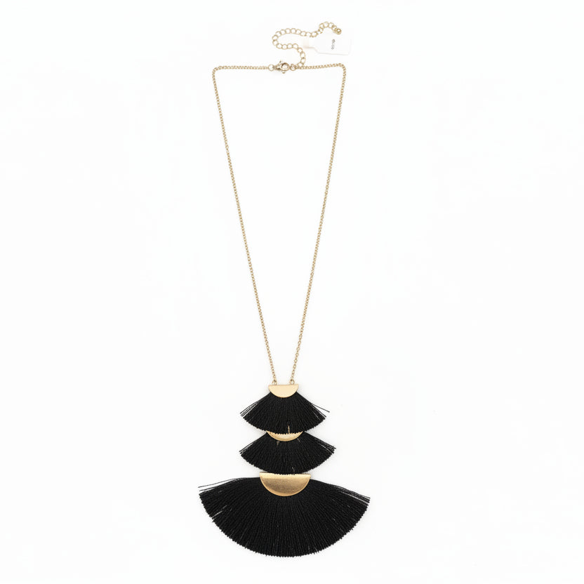Necklace with black tassel pendants on a white surface
