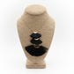 Black tassel earrings on a beige jewelry display