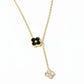 Gold necklace with black and white floral pendants on a white background