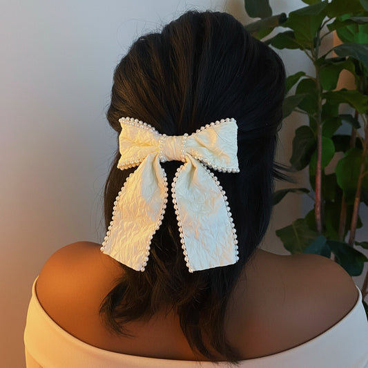 White lace hair bow on a person's head with a blurred background