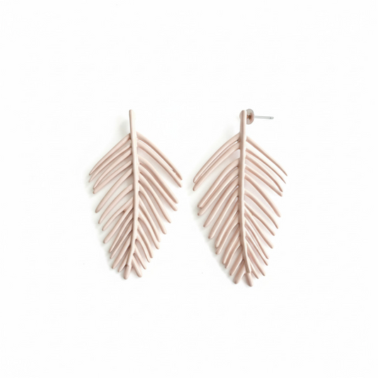 Pale pink palm leaf-shaped earrings on a white background