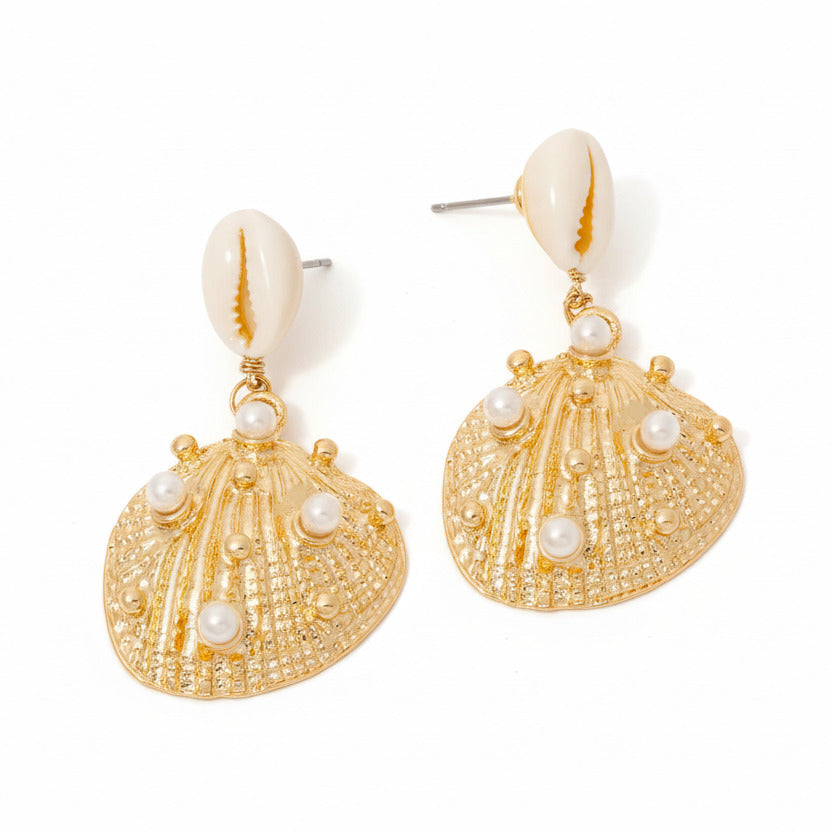 Gold shell-shaped earrings with pearl accents on a white surface