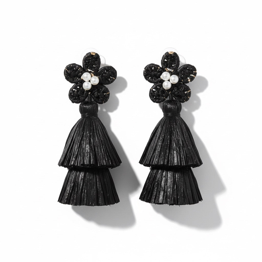 Black raffia earrings with floral tops on a white background