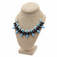 Necklace with blue, navy, and white beads on a brown bust