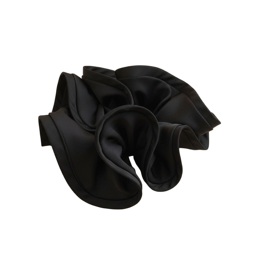 Black satin hair scrunchie on a white surface