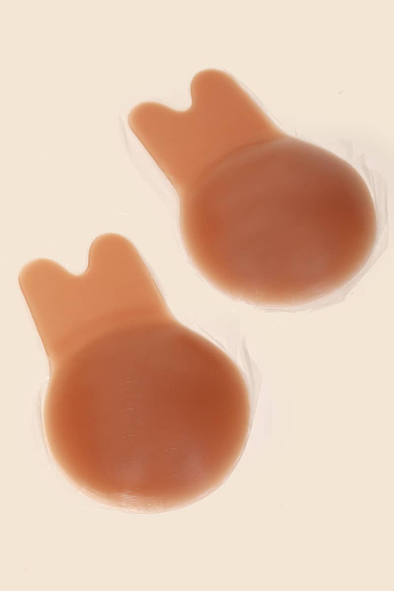 Two brown silicone cupping devices on a beige background