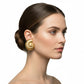 Gold earring on a female head against a white background