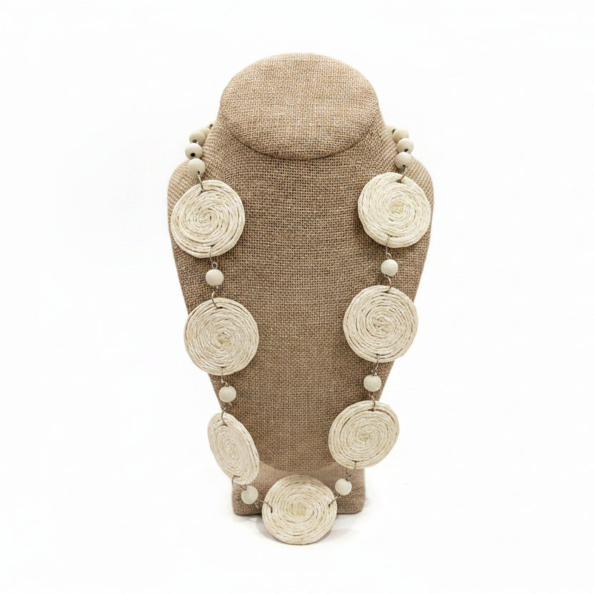 Necklace with circular beads on a mannequin bust against a white background