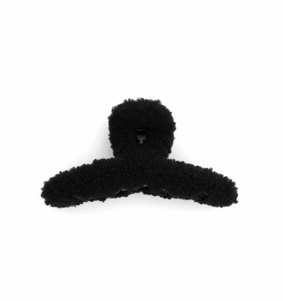 fuzzy black hair clip on a white background