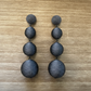 Pair of silver threaded earrings on a wooden surface.