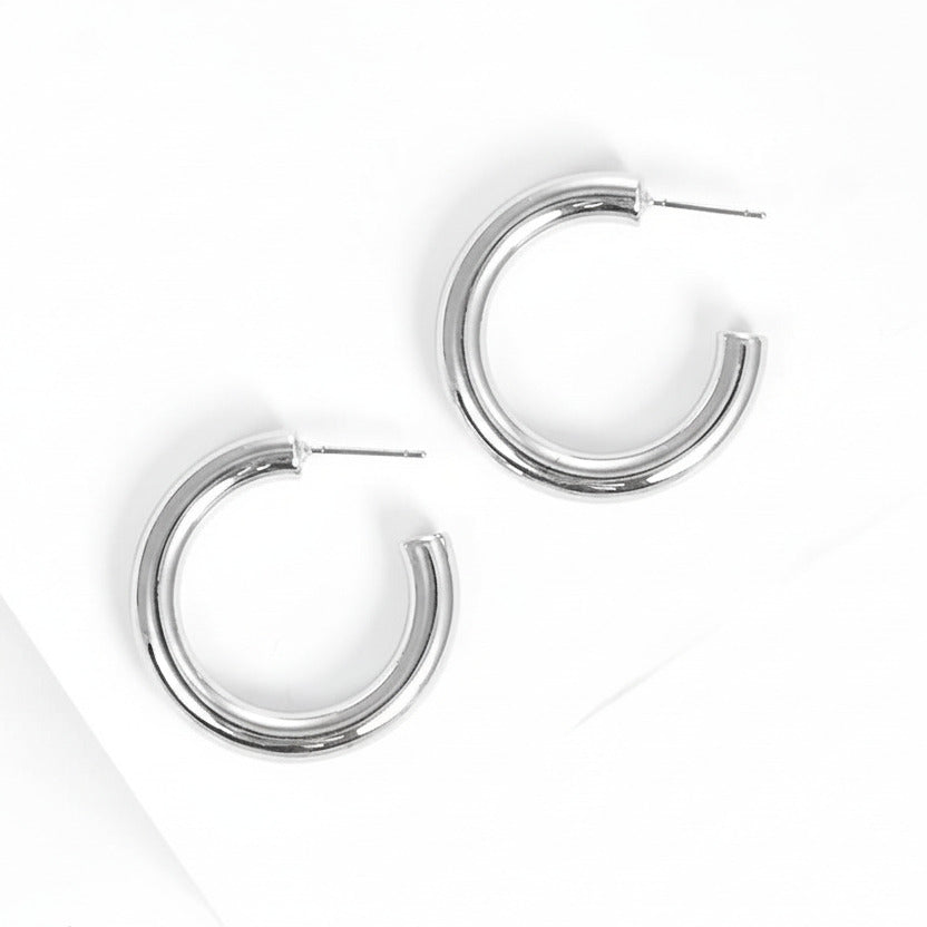 Silver hoop earrings on white background