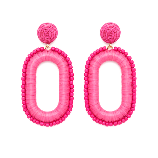 Pair of pink raffia oval shaped earrings on white background