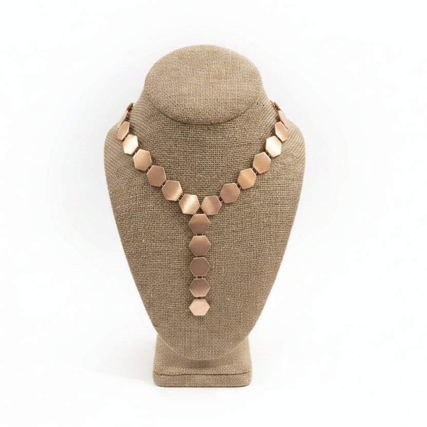 Necklace on a brown mannequin bust with a white background