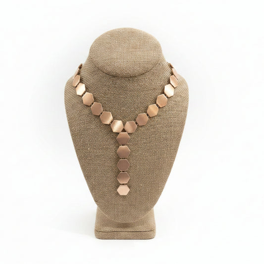 Necklace on a brown mannequin bust with a white background