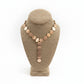 Necklace on a brown mannequin bust with a white background