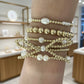 Stack of gold and pearl beaded bracelets 