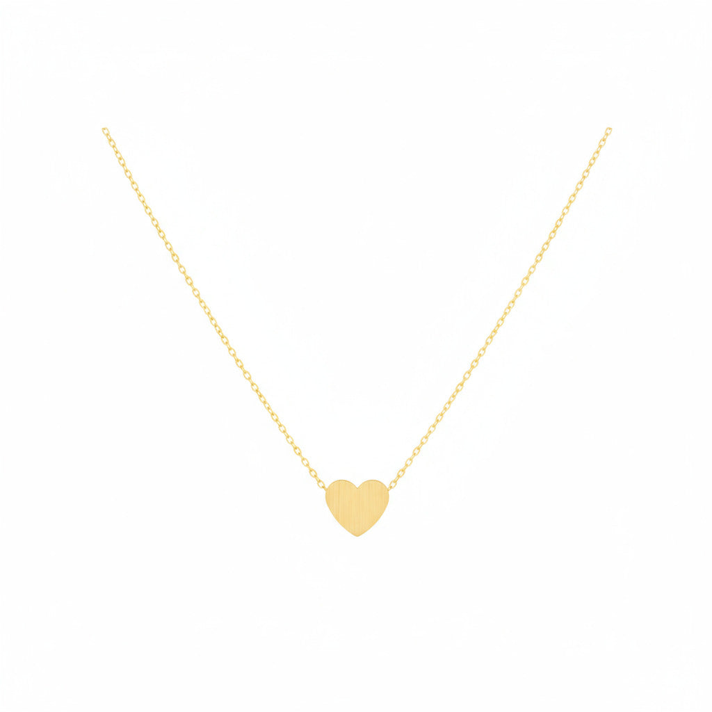 Gold heart necklace on a white background