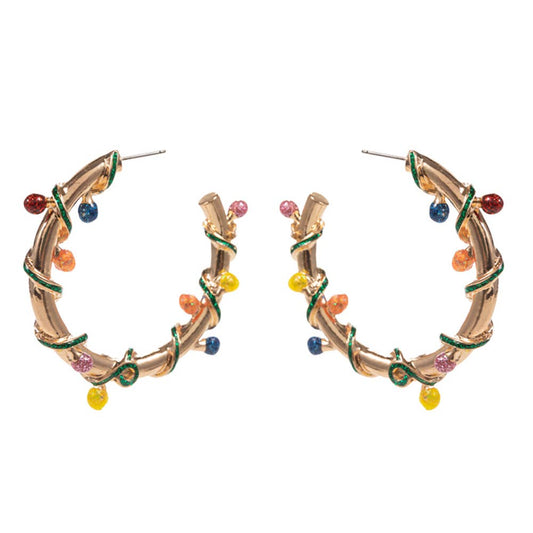 Gold hoop earrings with christmas lights a white background