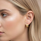 model wearing small chunky gold huggie hoop earring