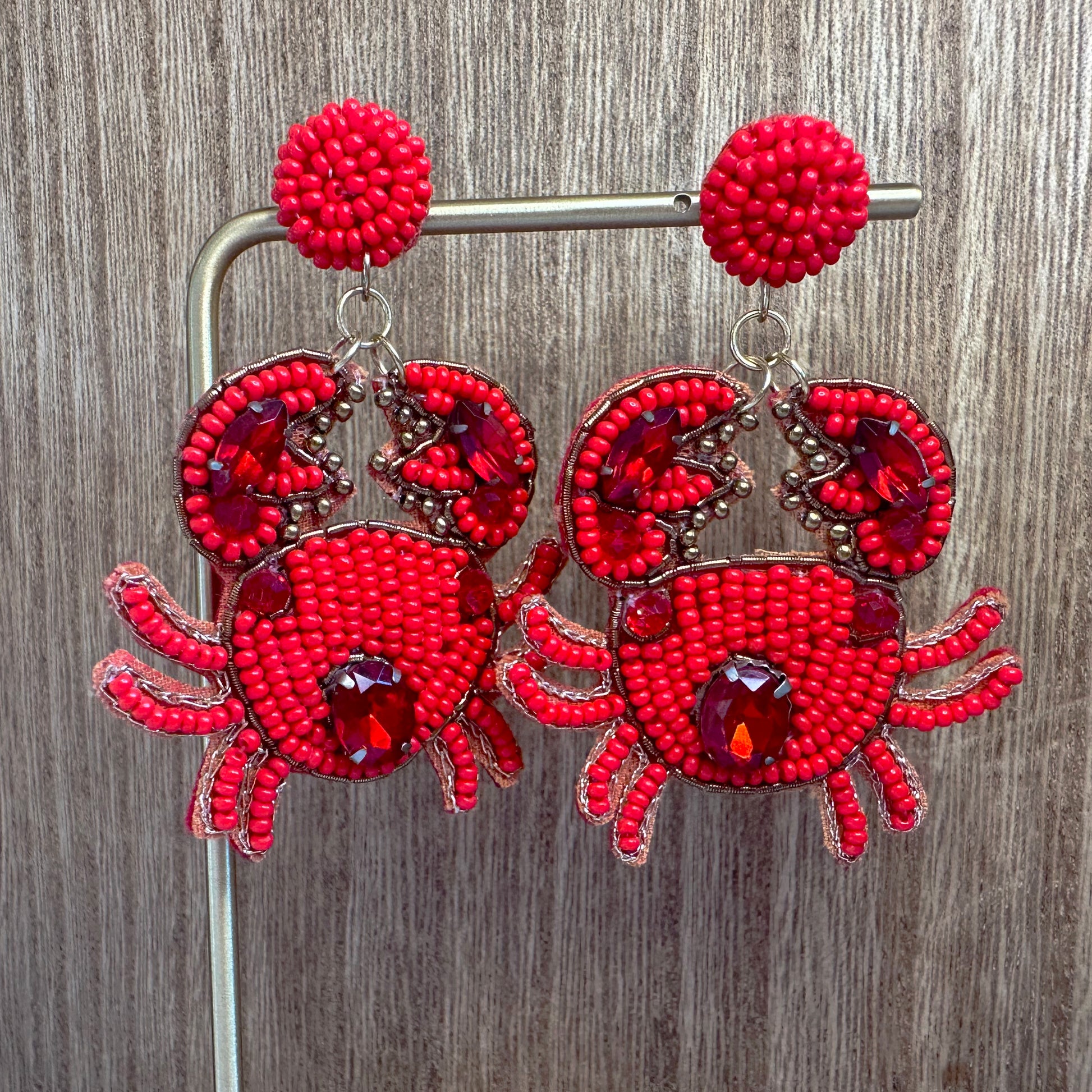 crab beaded earrings against wood background