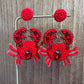 crab beaded earrings against wood background