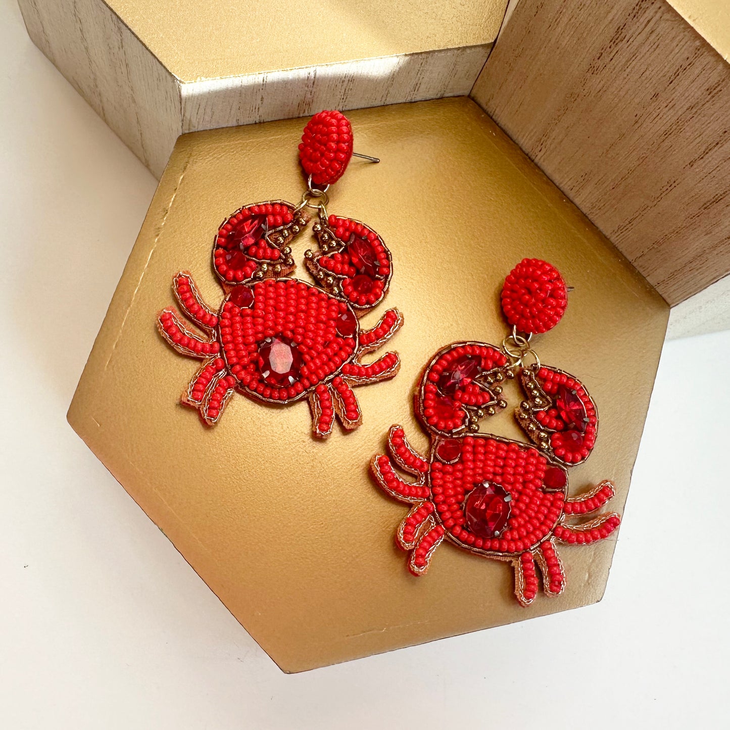 crab beaded earrings against gold background