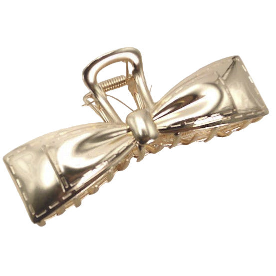 Gold bow-shaped hair clip on a white background